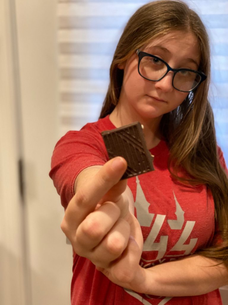 Olivia showing a piece of Almond Dark by GATSBY Chocolate Bar